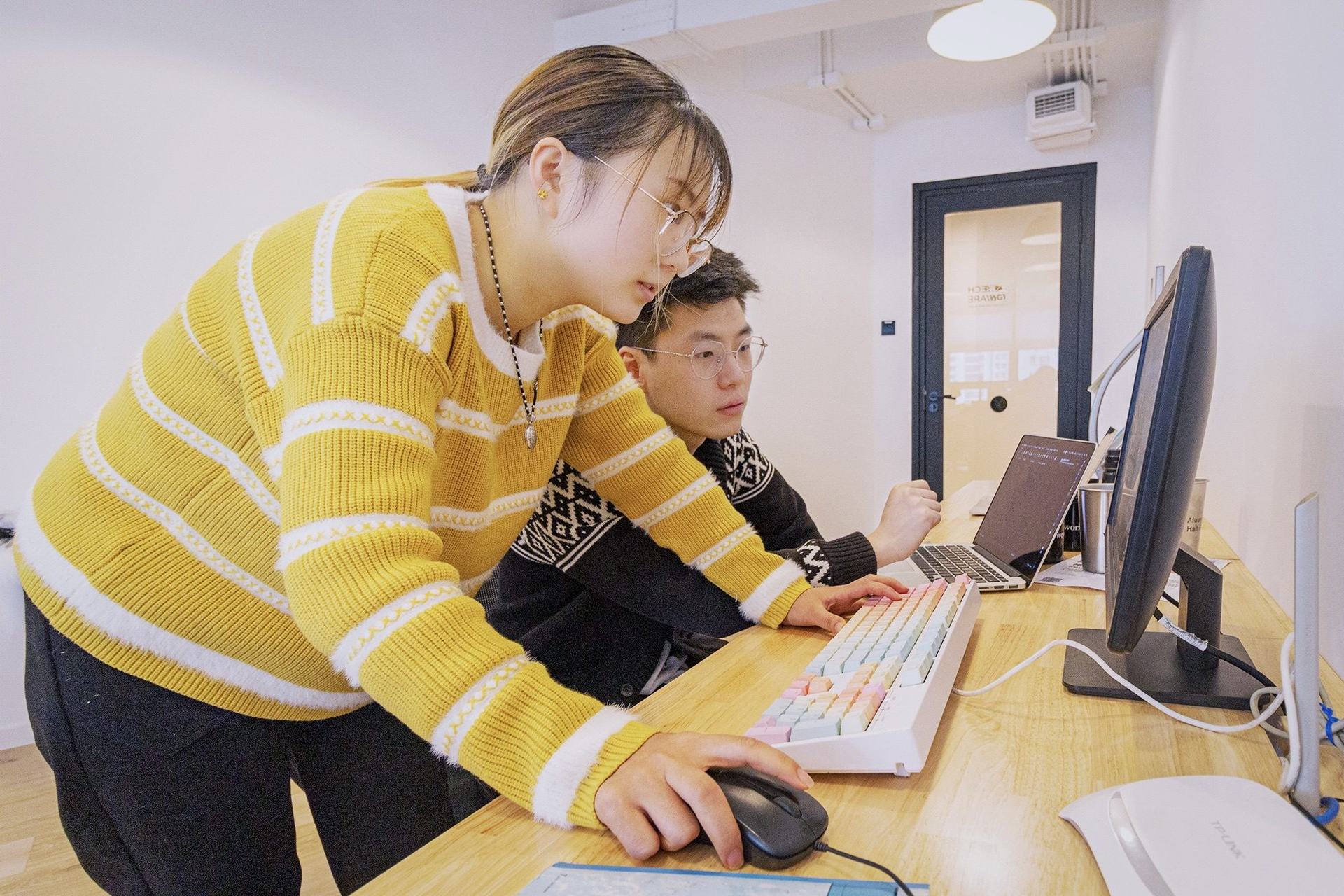 Two engineers working through a problem together at a screen
